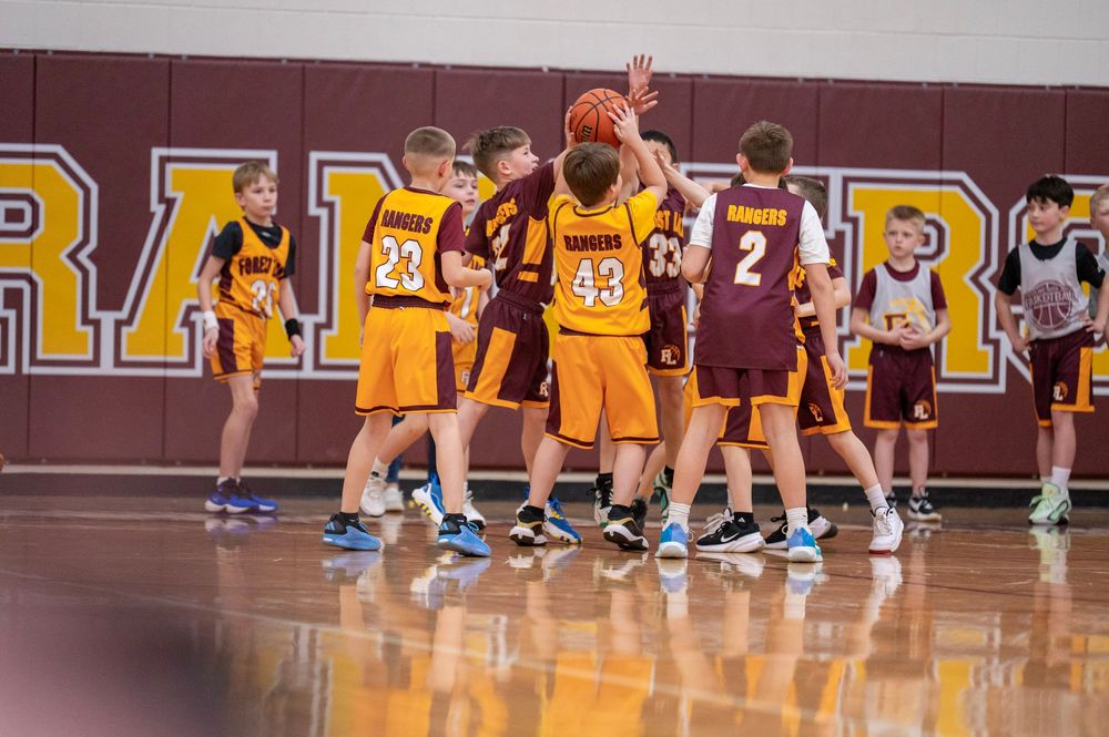 Basketball players line up on the court during a game break.