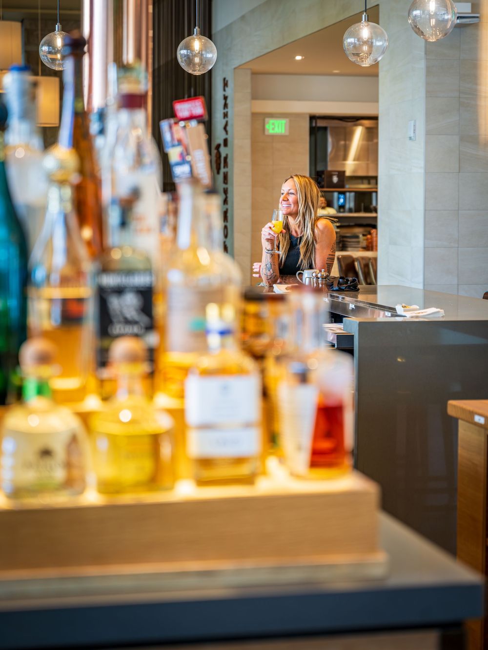 A woman at the bar in the Former Saint by Denver Hospitality, Travel & Tourism photographer Captain Colorado Photography.