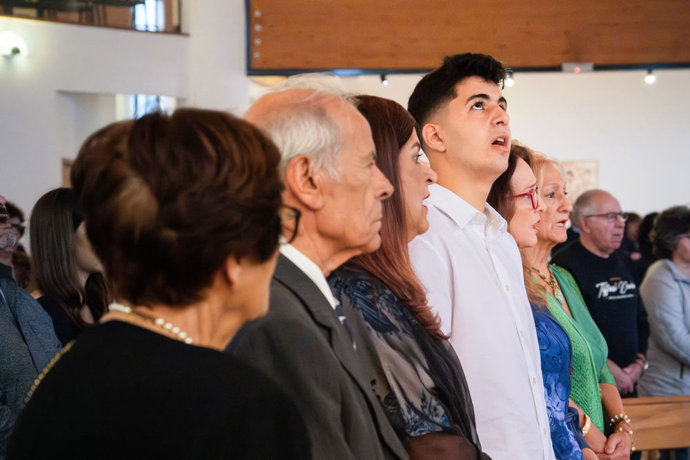 Congregation standing together in a modern church during a religious service or ceremony.