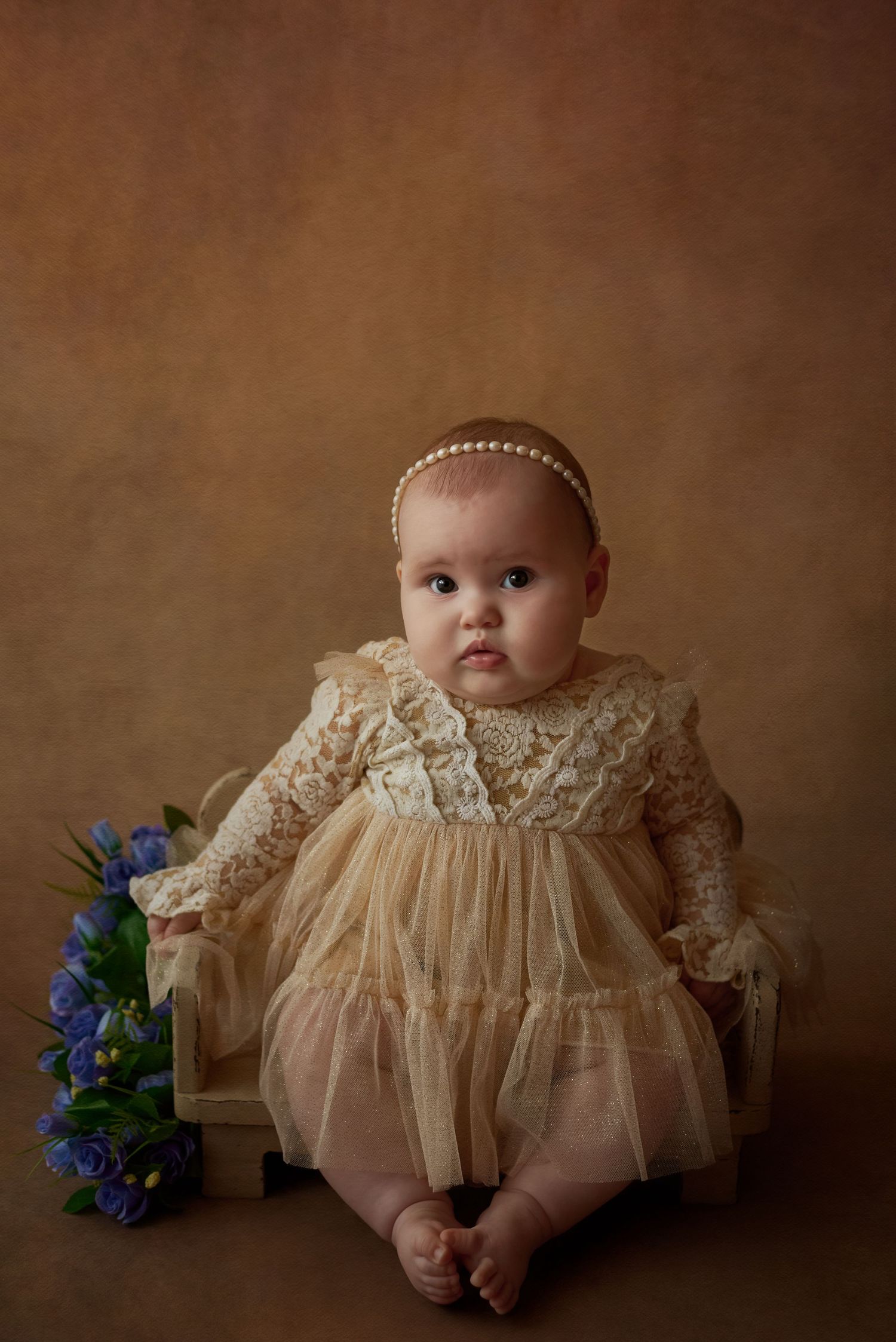 Fotografia de bebê com vestido longo vintage em cenário fine art de tons quentes, por Rose Carvalho.