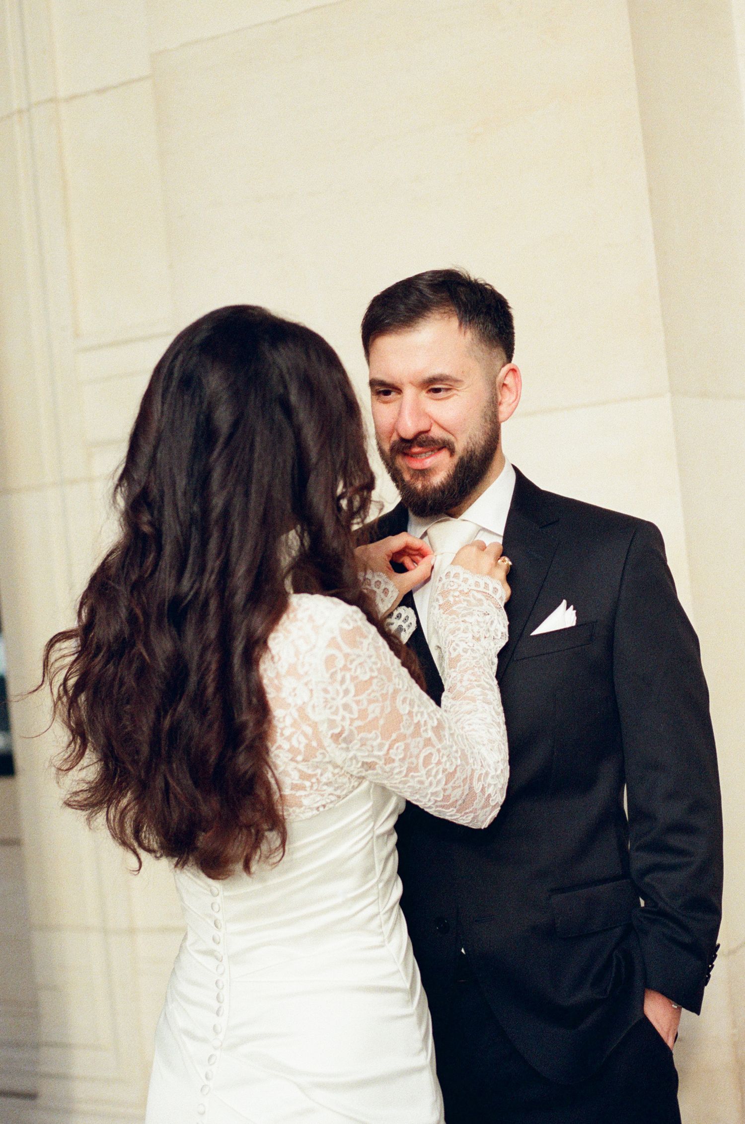 A smiling groom in a black suit in Paris captured on paris film photography by paris film photographer, paris cinematic wedding photos