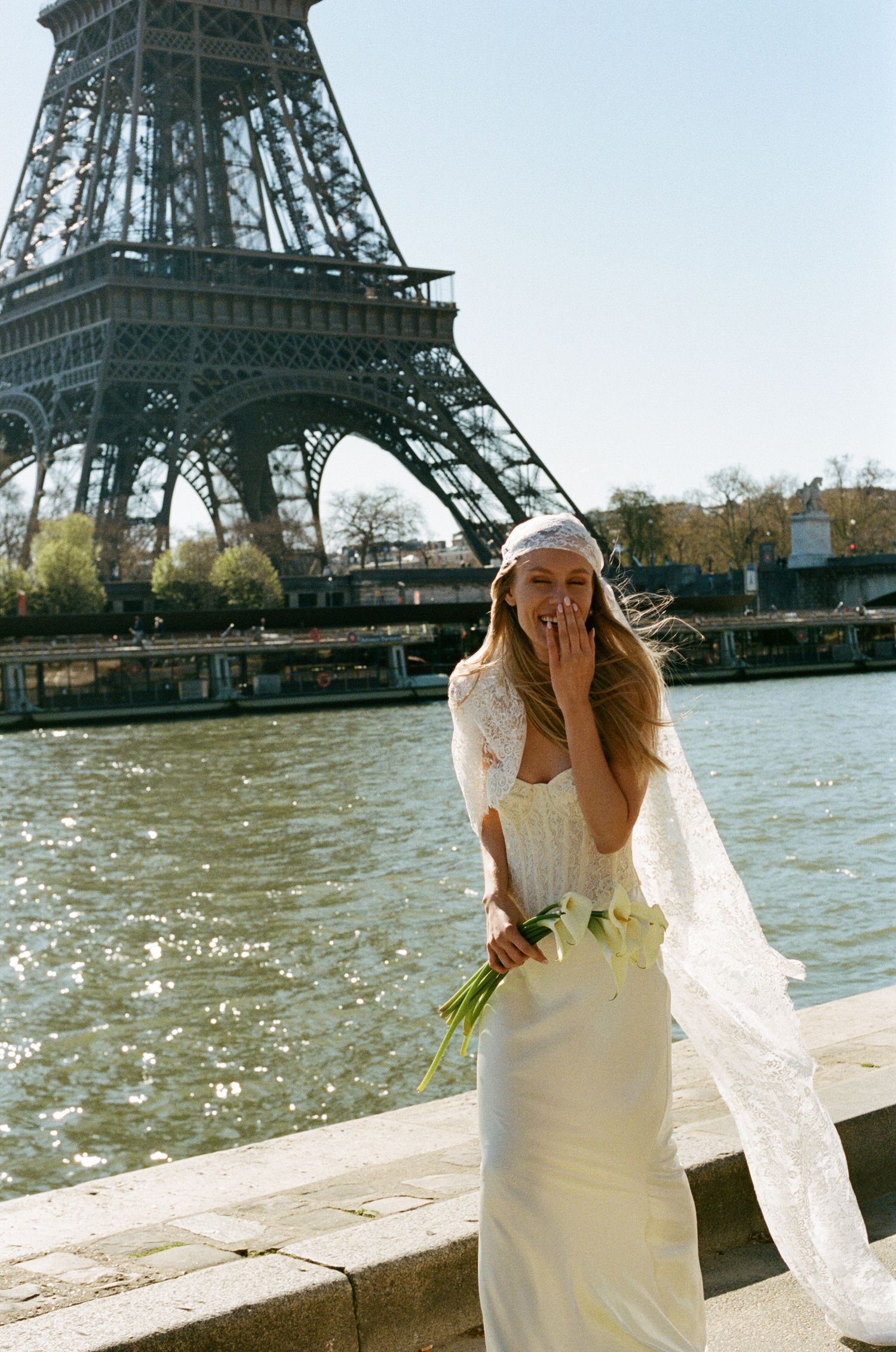 Bride in lace wedding dress and veil in front of Eiffel Tower. Editorial eiffel tower wedding photos. Not cheesy. Paris film wedding