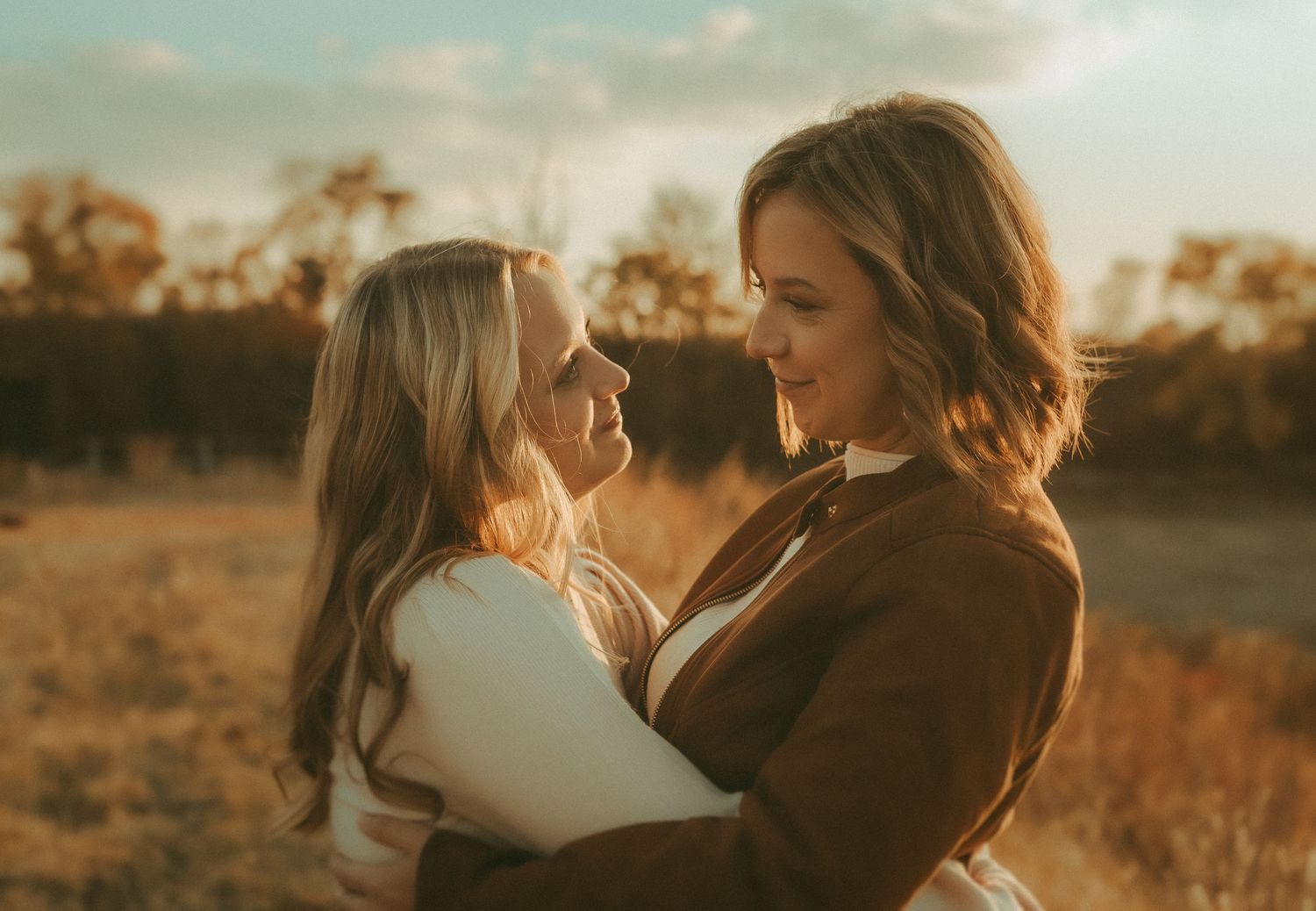 mother and daughter embracing at sunset in field – emotional connection captured in Kansas couples session