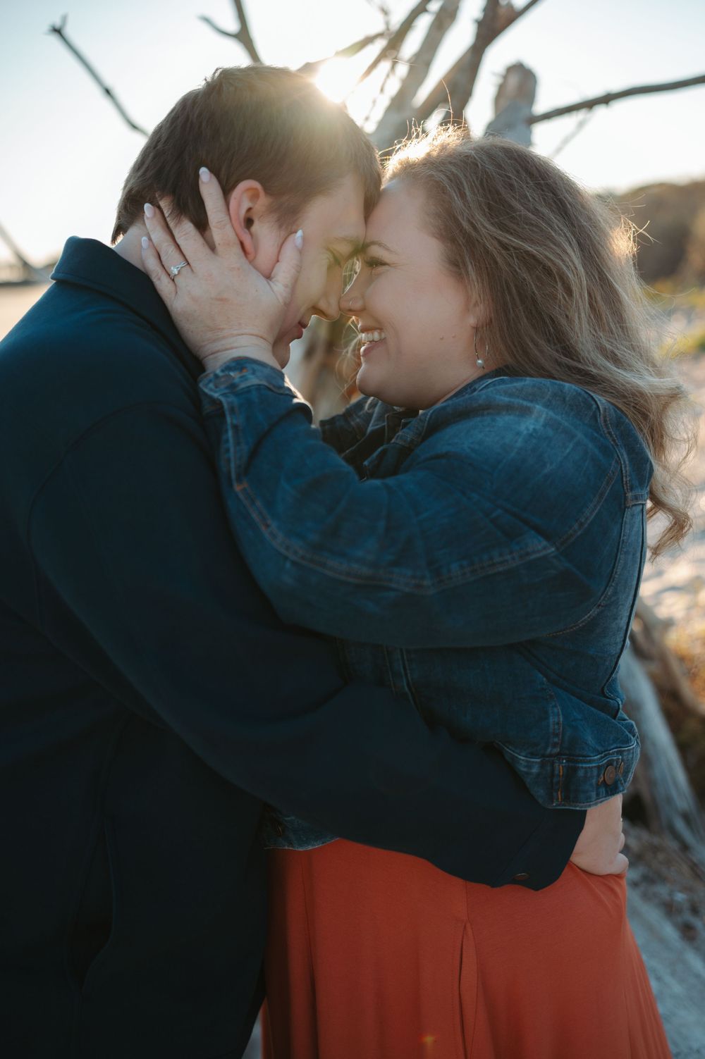 A couple embraces and kisses in a series of romantic outdoor photos showing them in denim jackets and orange clothing.