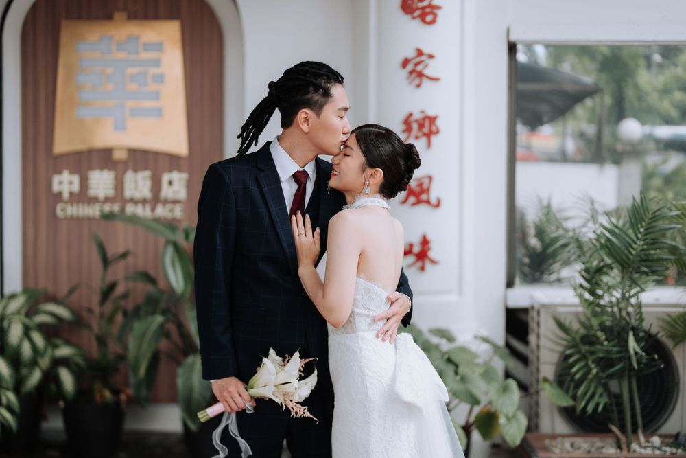 A candid wedding moment captured outside a traditional Chinese building.