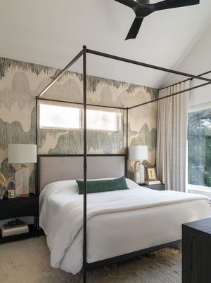 Contemporary bedroom with canopy bed and abstract wavy wallpaper.
