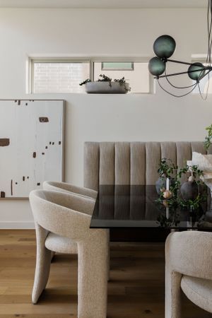 Modern dining room with curved chairs and sculptural pendant light fixture.