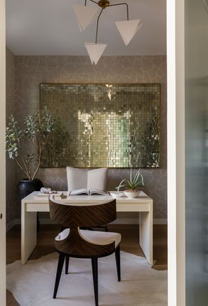 Contemporary vanity area with geometric wallpaper, metallic tile mirror, and triangular pendant lights.