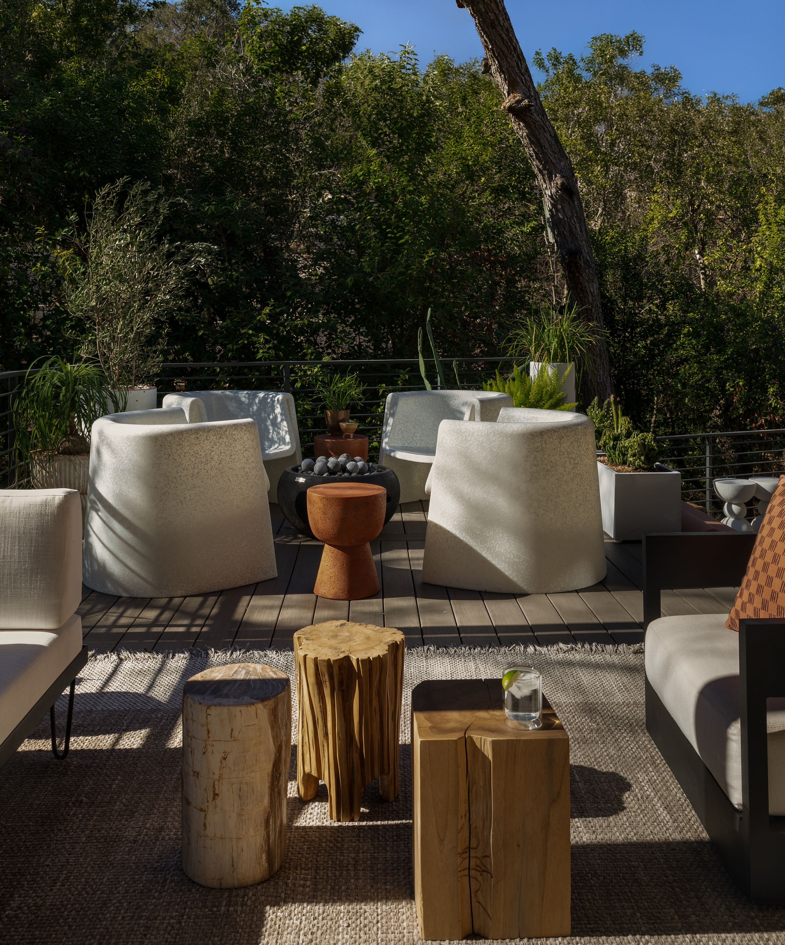 Outdoor terrace with modern white lounge seating and natural wood block accent tables.