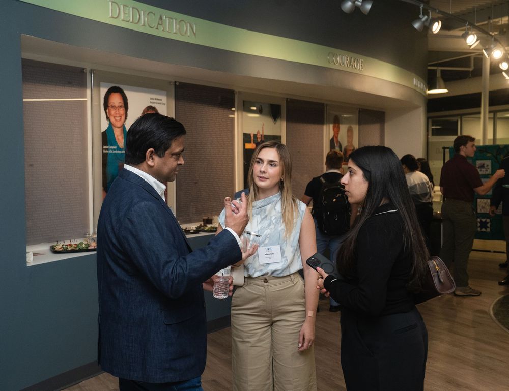 People engaged in conversation and interaction in a modern office hallway or corridor setting.