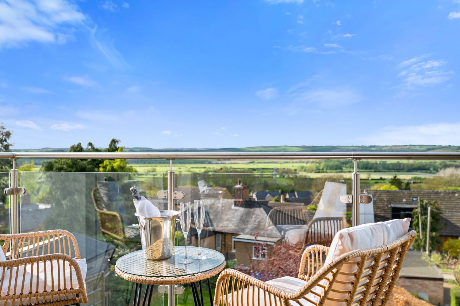 Property photography lifestyle image picturing champagne on a balcony with incredible panoramic countryside views for a real estate listing.