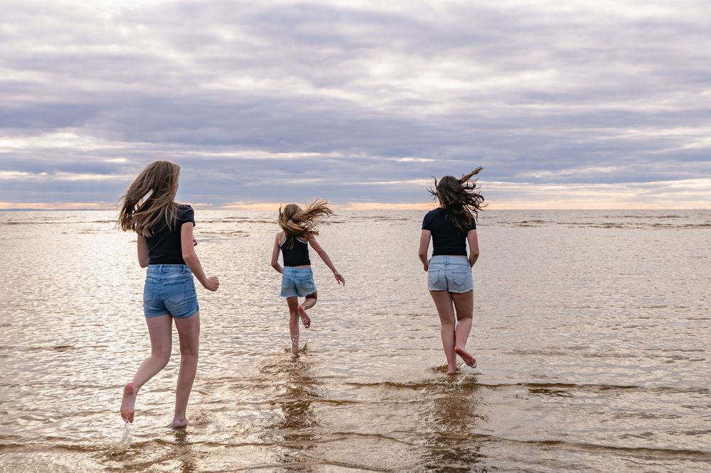 Trois filles courant vers l’eau à la plage de Saint-Gédéon
