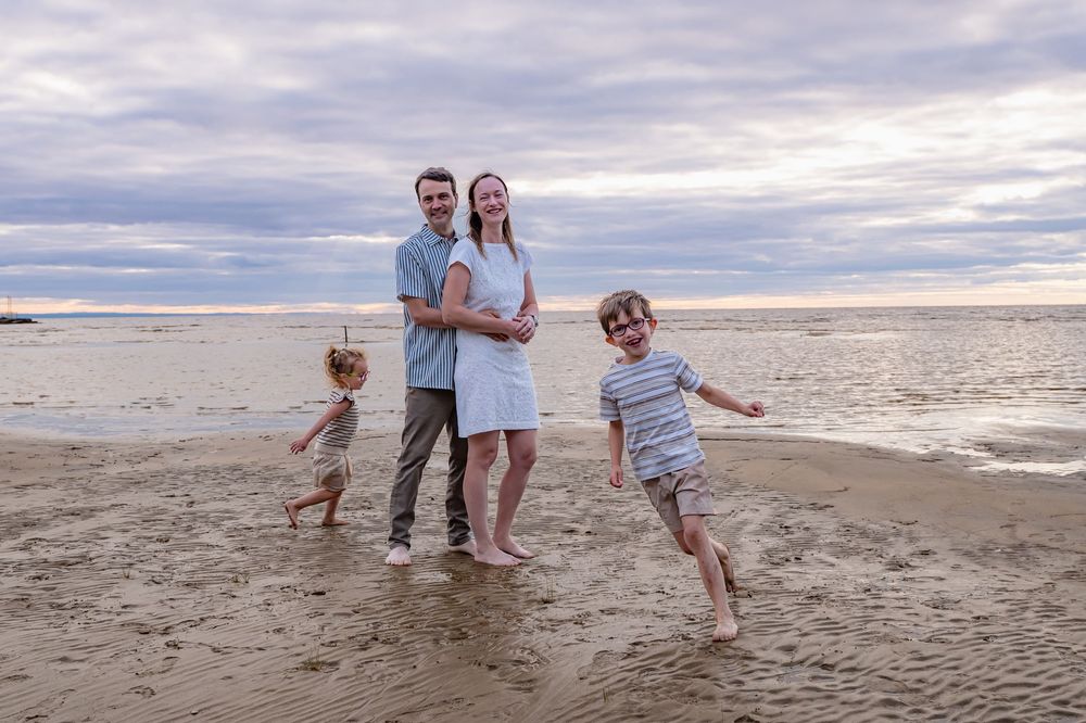 Portrait naturel d’une famille à la plage de Saint-Gédéon, parents posant et enfants en mouvement autour