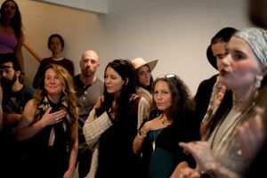 Engaged audience members watch intently during an indoor musical performance.