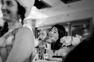 A candid black and white shot of people laughing together at a social gathering.
