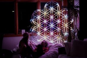 Illuminated geometric light installation creating star pattern in dark room.