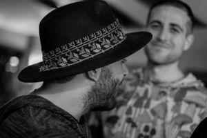 A candid black and white photo showing two people in conversation.