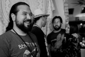A candid black and white photo of someone smiling at an indoor event.