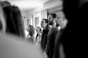 Black and white photo of people standing in a line during what appears to be a group gathering.