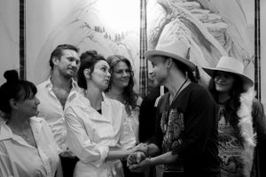 Black and white candid photo of group interaction at social gathering.