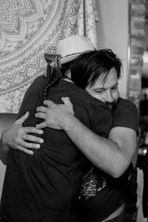 An emotional black and white photo capturing two people sharing a warm embrace.
