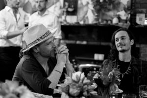 Two people engaging in conversation at a bar in black and white photography.