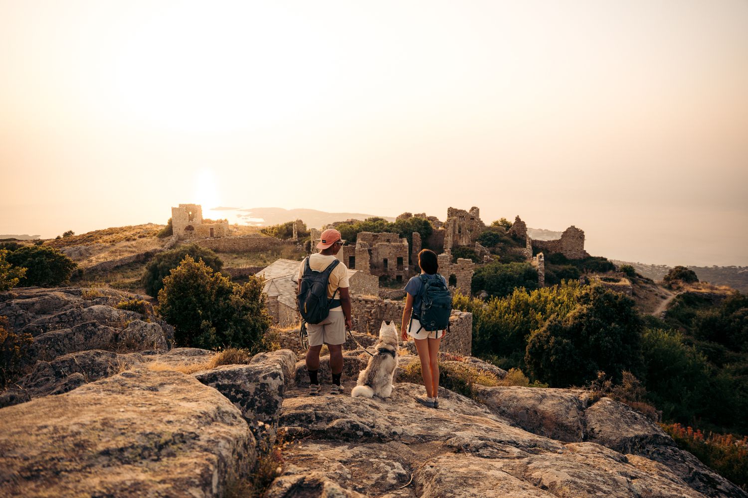 couple de randonneur avec leur chien au coucher du soleil aux ruines d'occi en balagne au dessus de l'ile-rousse