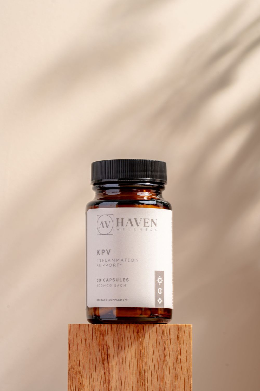 Four amber glass supplement bottles arranged on wooden blocks with minimalist branding and soft lighting against neutral background.