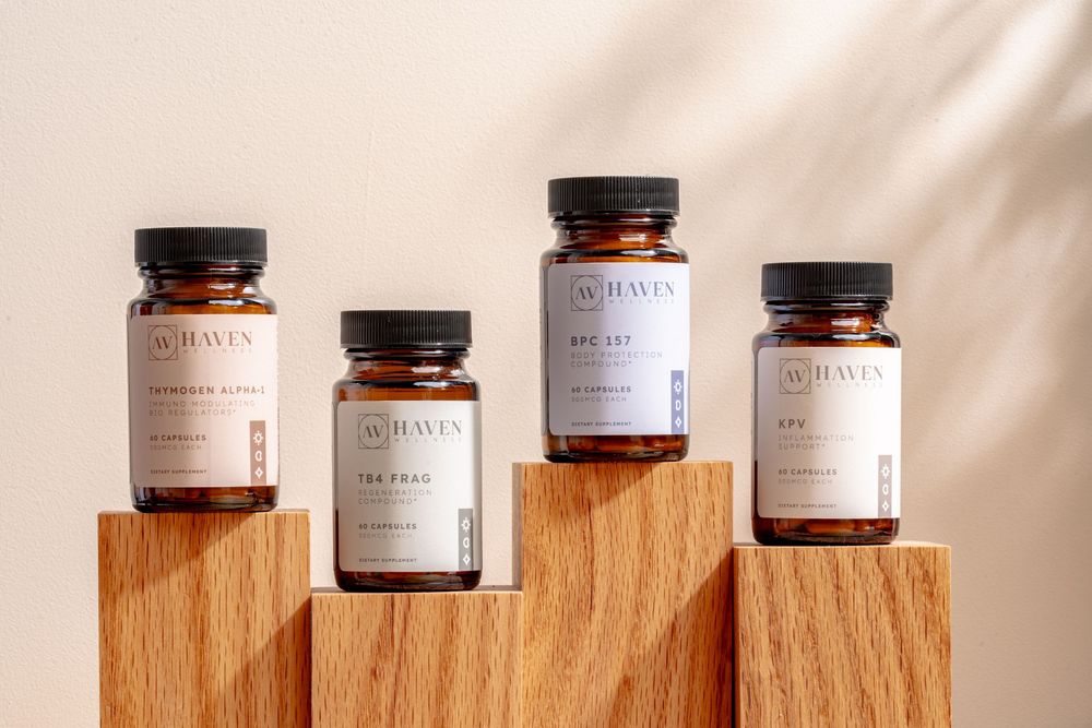 Four supplement bottles displayed on wooden blocks against a beige background, showcasing premium wellness packaging.