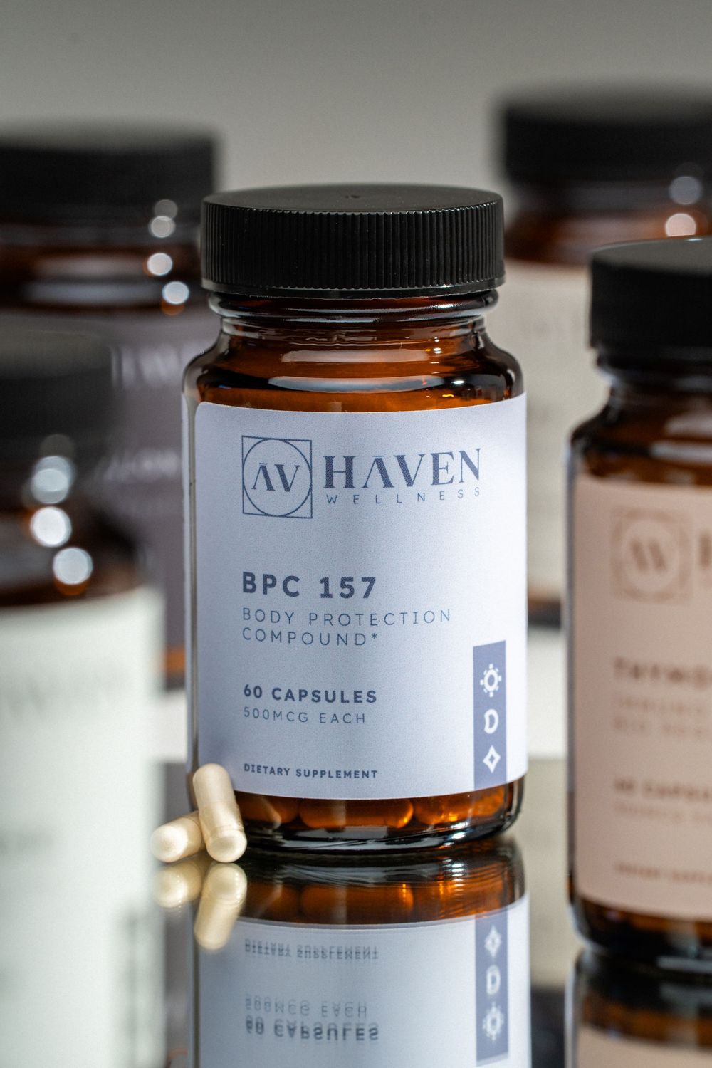 Close-up shot of amber glass supplement bottles with minimalist white labels showing Haven brand packaging design.