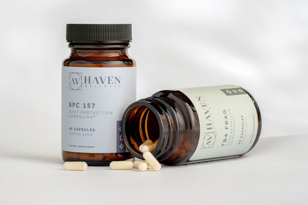 Two amber glass medicine bottles with supplements or pills spilled out on a light surface with soft natural lighting.