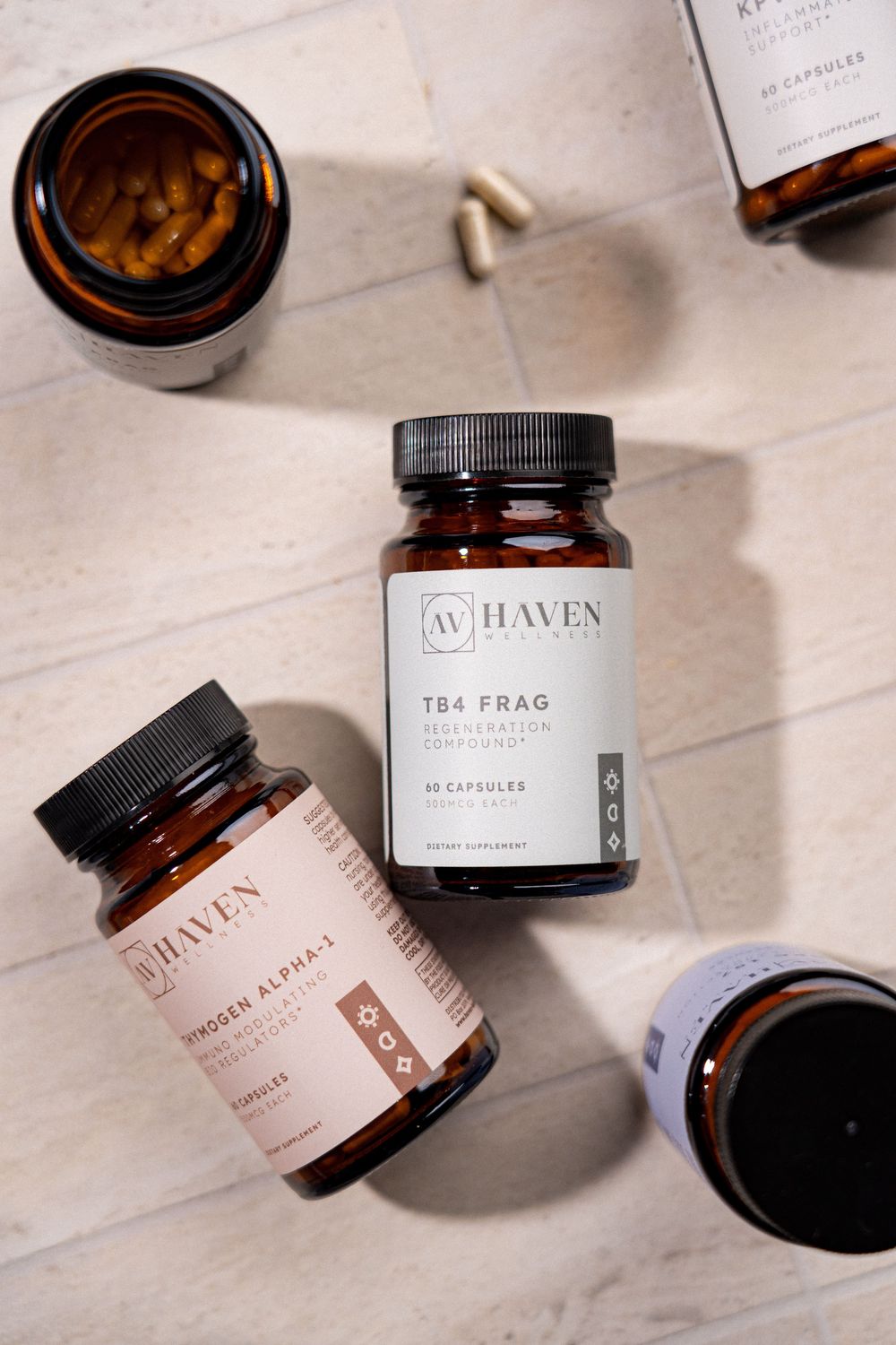 Multiple amber glass supplement bottles from Haven Wellness arranged on a light marble surface.