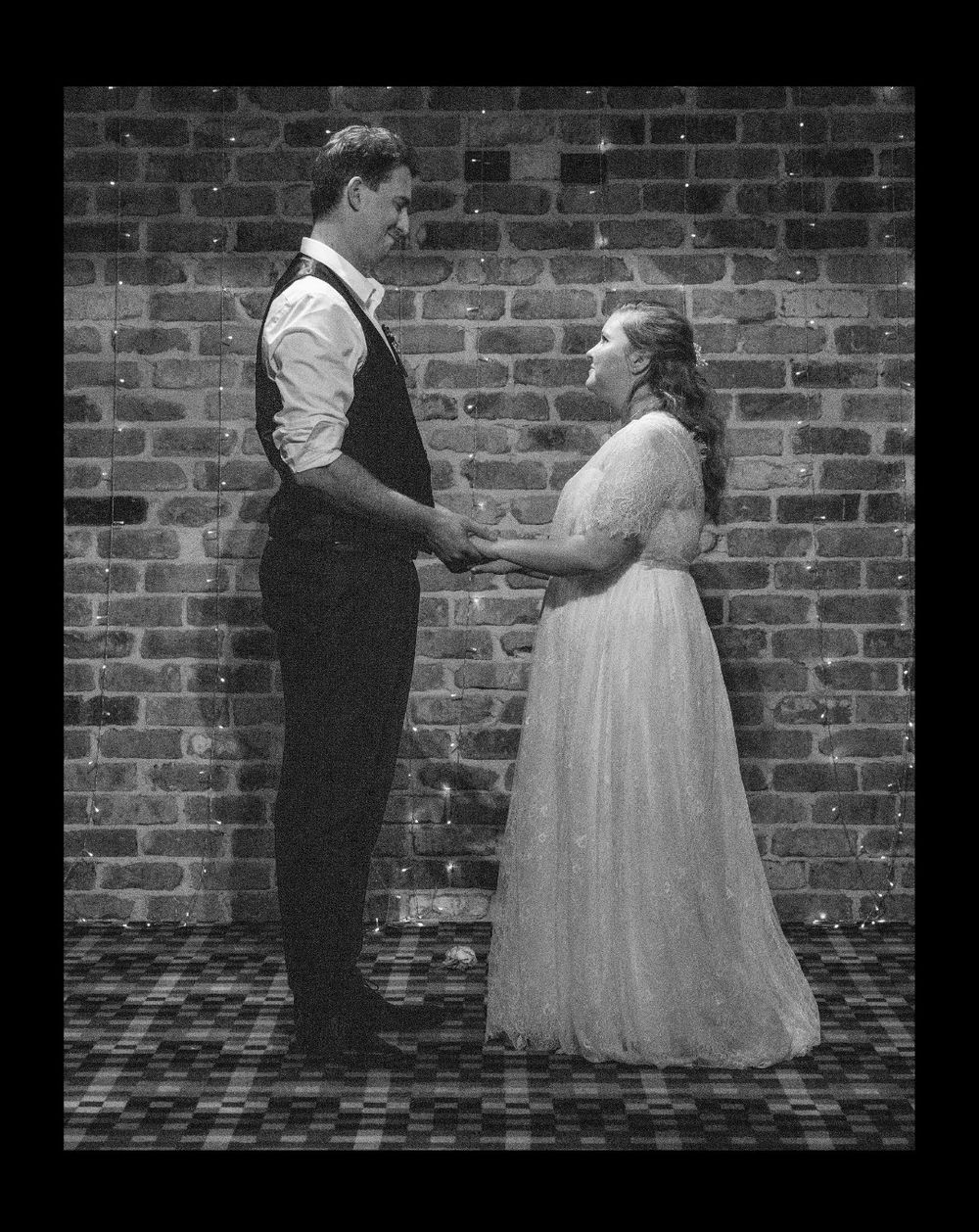 Happy bride and groom standing holding hands