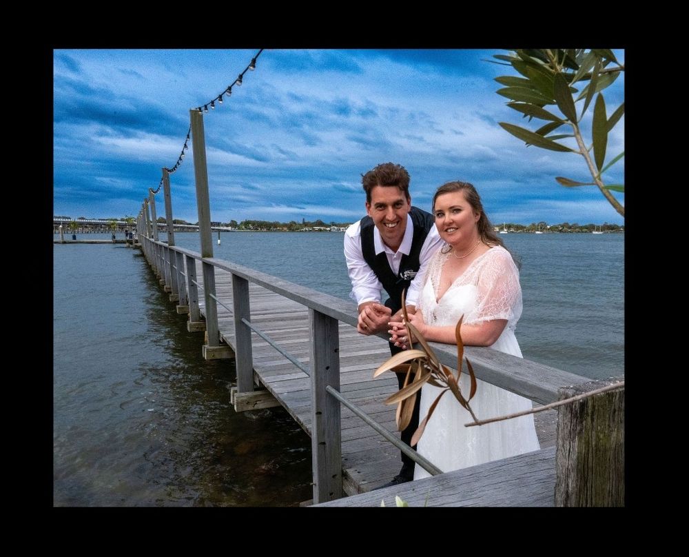 Happy bride and groom standing on a jetty