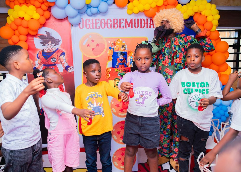 Kids enjoying entertainment activities at colorful birthday party with balloon decorations.