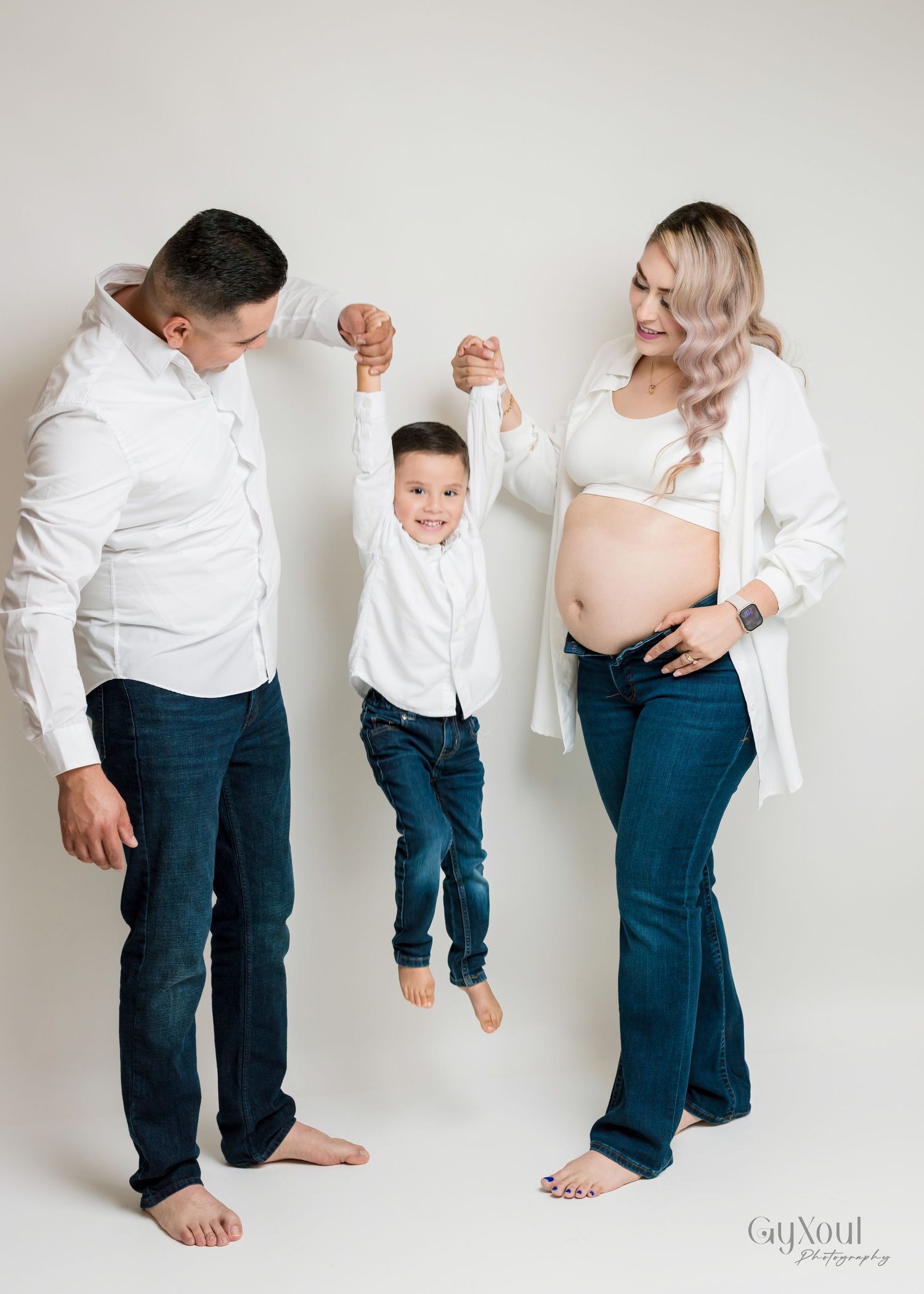 Panoramic sequence showing a toddler in white shirt and jeans playing and moving against a light wall background.