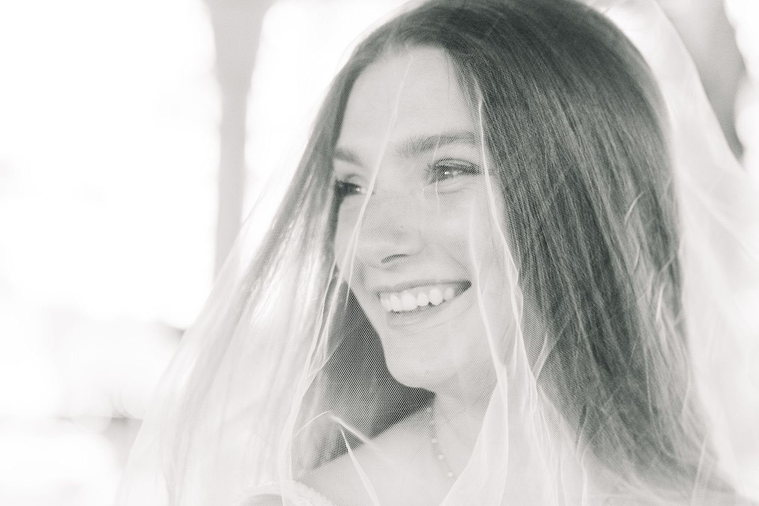 Black and white portrait photos of a woman smiling shown from multiple angles with long dark hair.