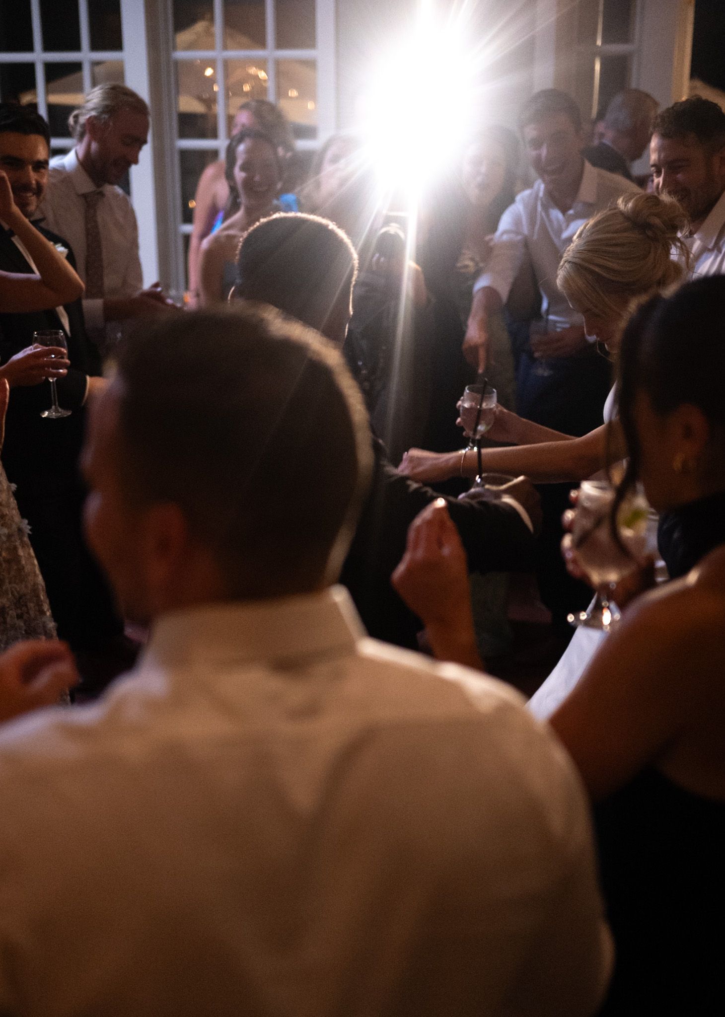 Crowd gathered at evening celebration with dramatic backlighting.