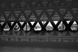 Geometric triangular patterns in a bridge structure creating symmetrical shadows and light.