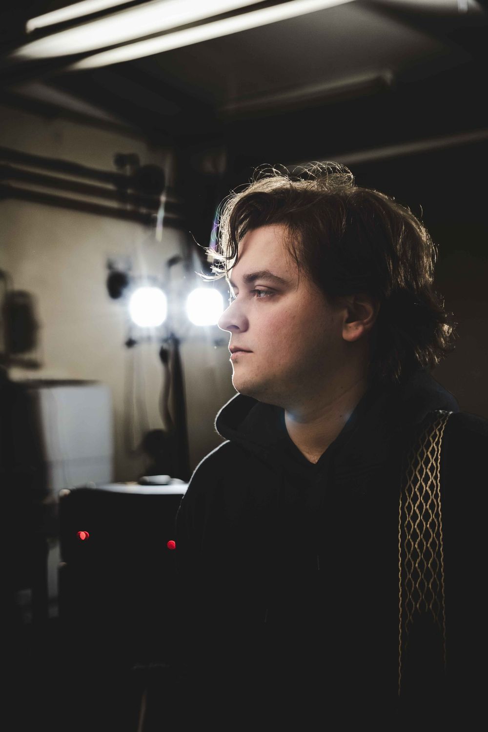 Moody profile shot of a musician in dramatic lighting.