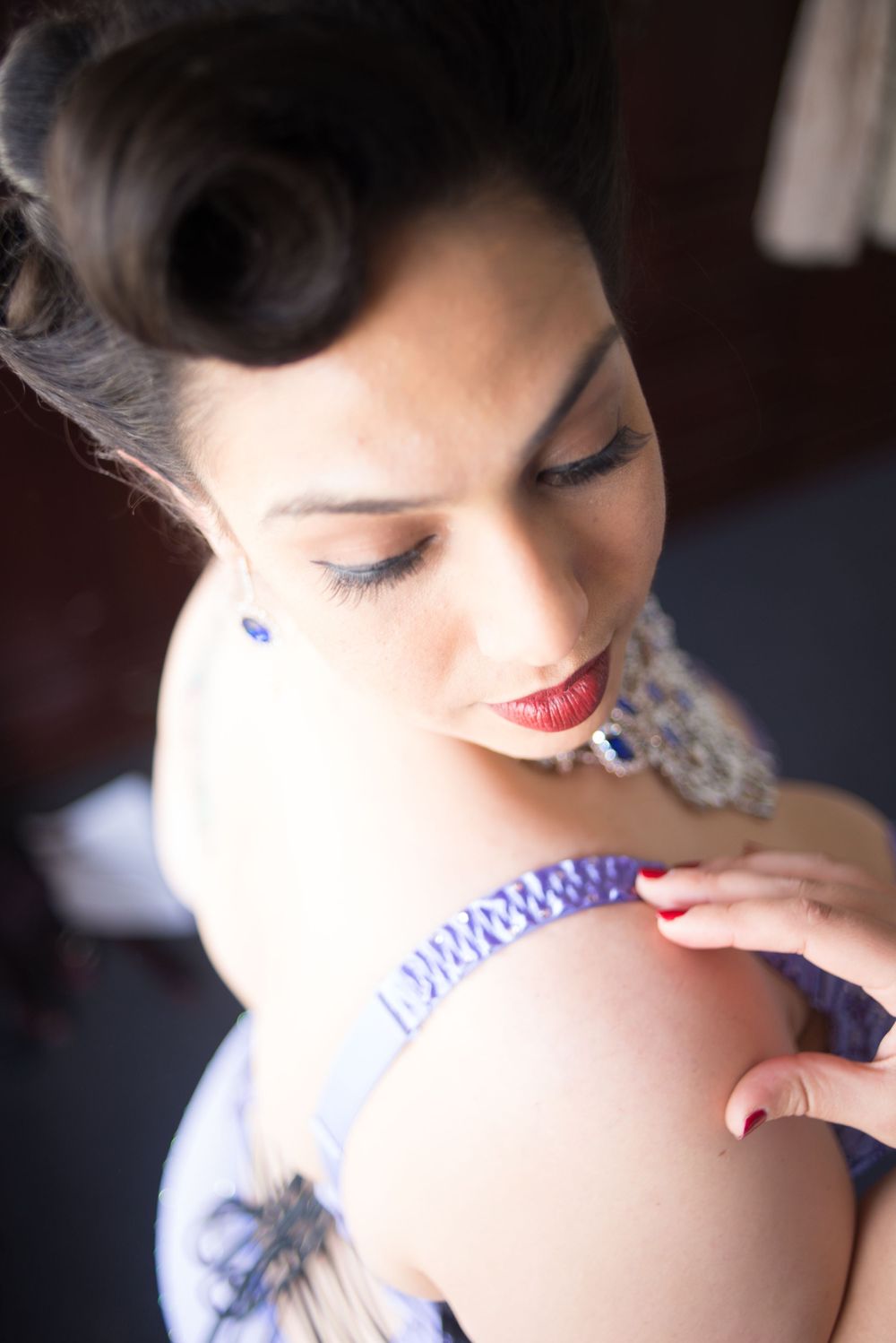 Close-up beauty shot with vintage hairstyle, red lipstick and purple accessories.