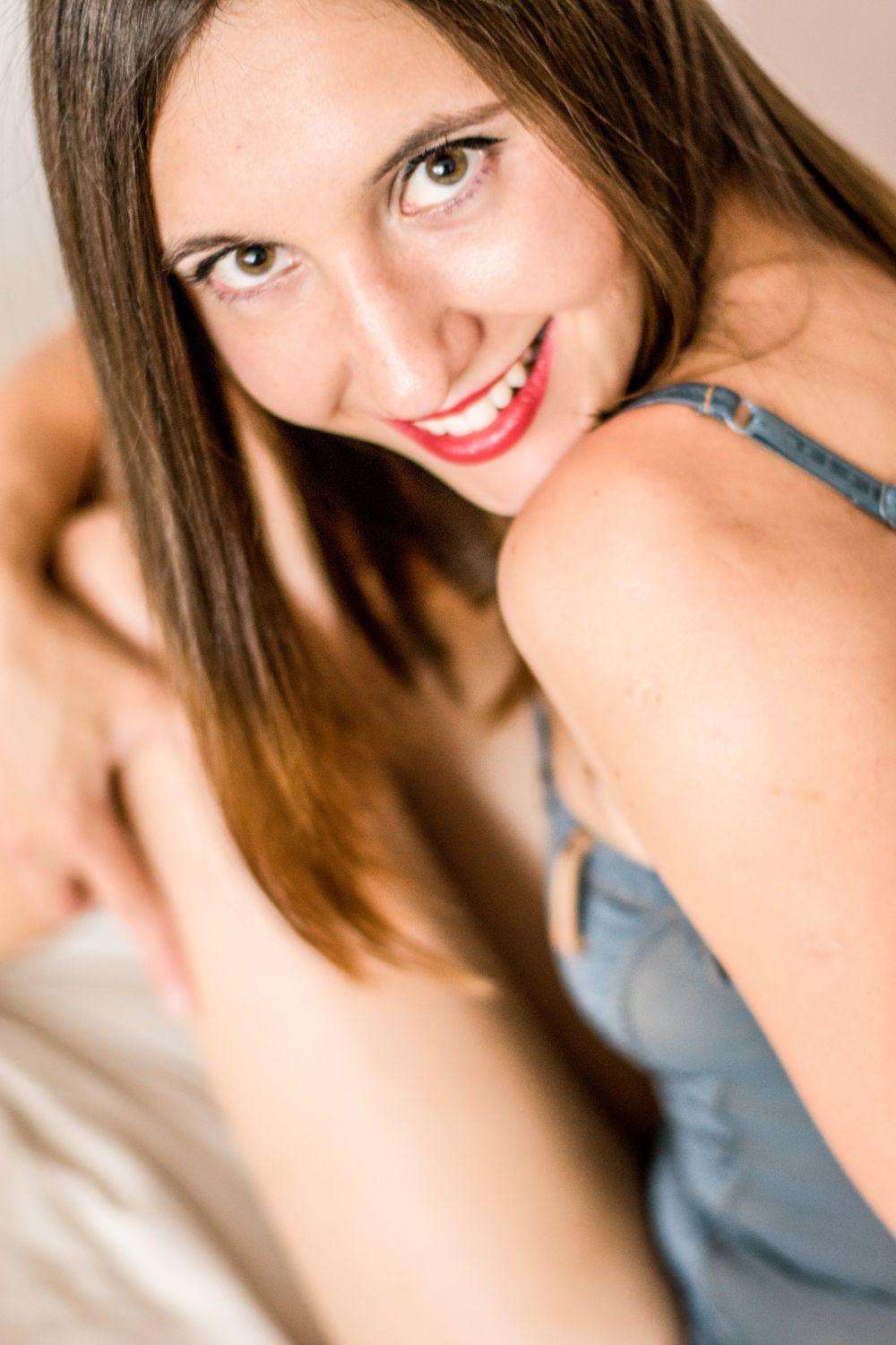 Close up beauty portrait of woman with bright smile in blue top.