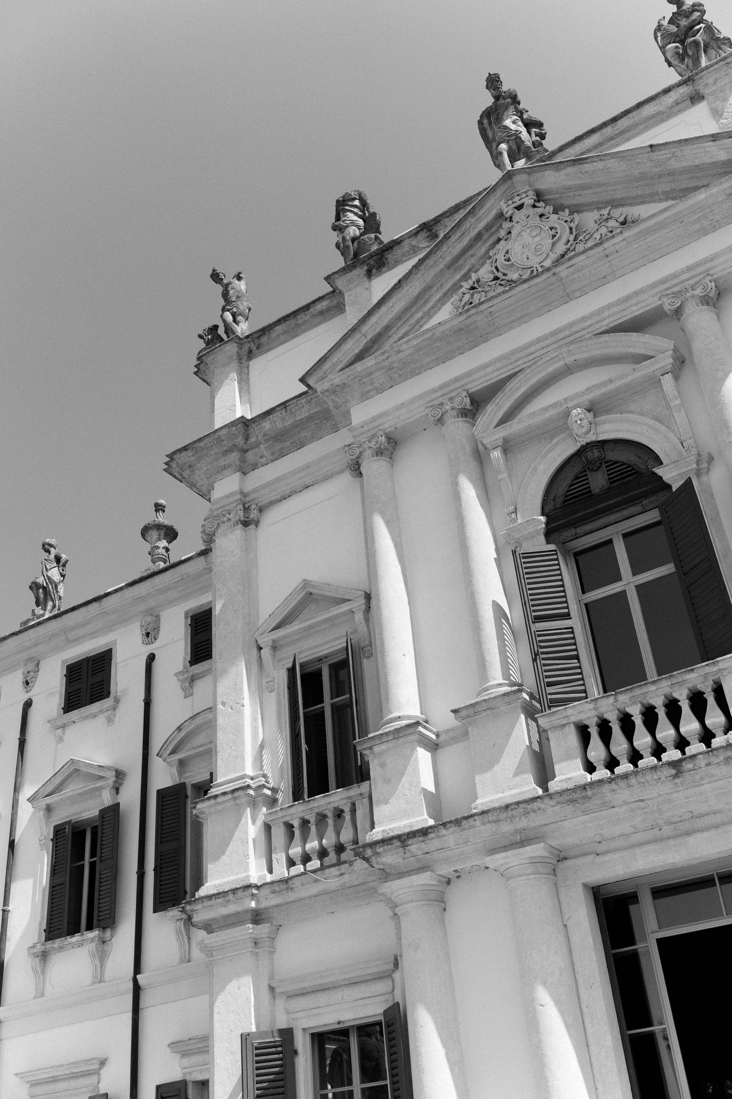 Architectural detail of white colonial style buildings with ornate balustrades and decorative elements in a row.