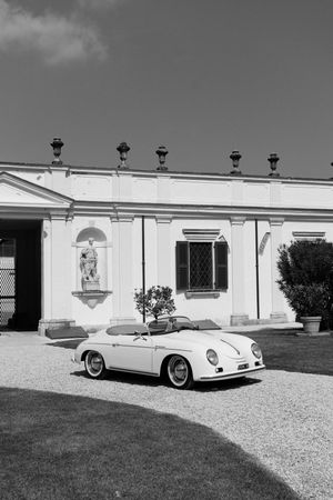 Classic white Porsche 356 luxury sports car photographed from multiple angles against a retro garage backdrop in black and white.