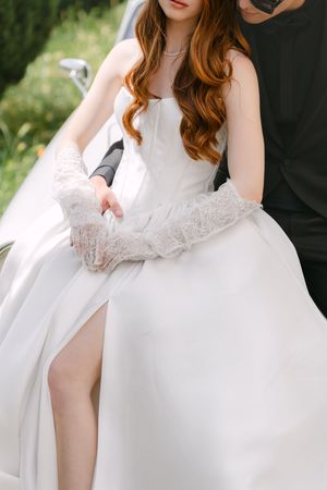 A bride in a flowing white wedding gown with delicate lace details showcased in a series of romantic portraits.