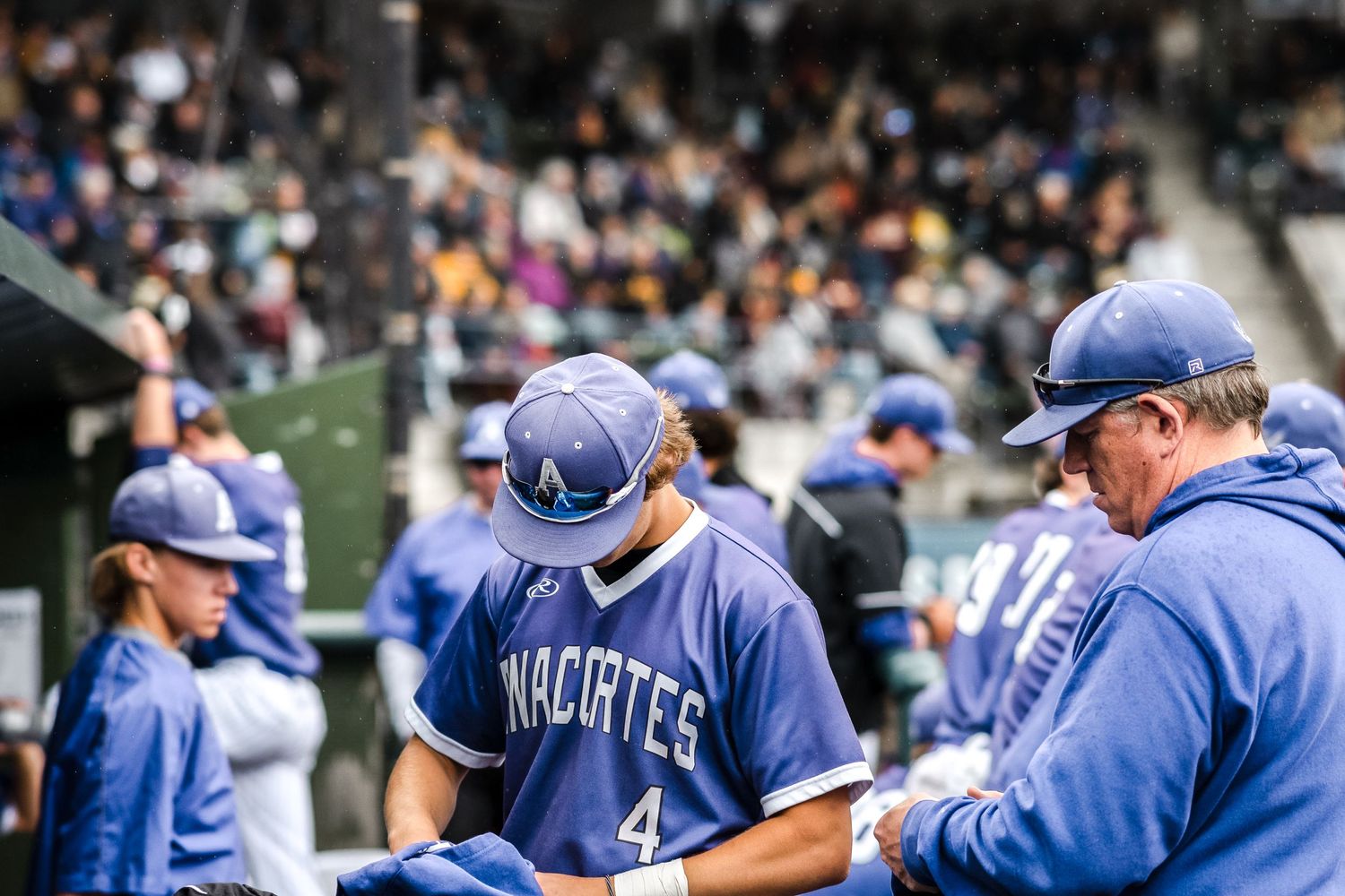 Baseball players in blue uniforms gather on the field during a game.