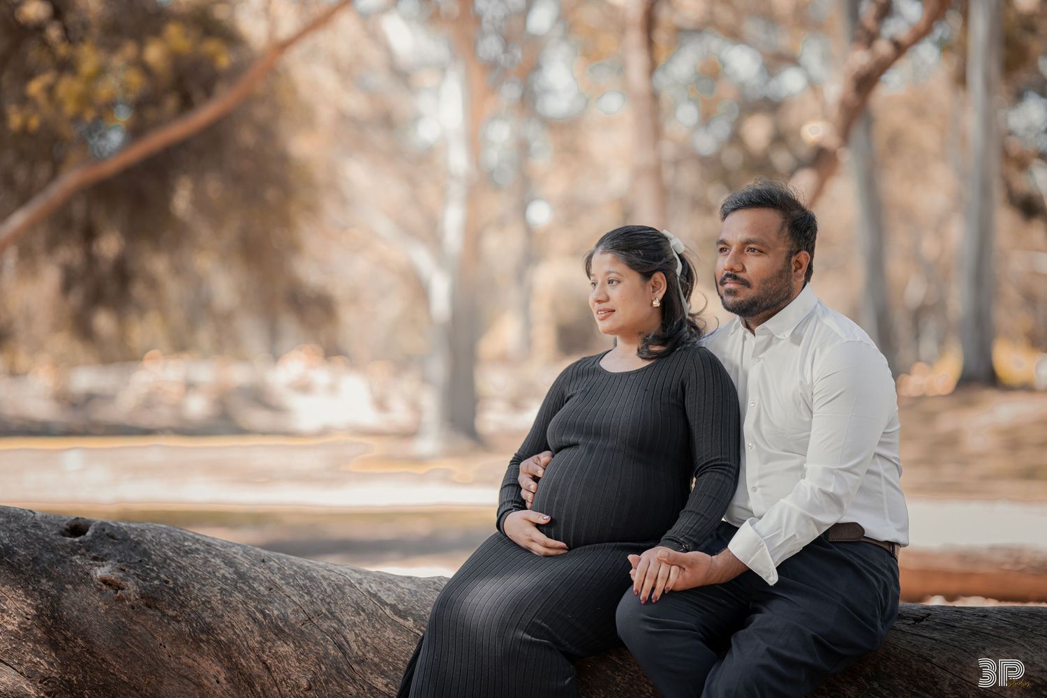 Expecting couple sharing a tender moment during a maternity photoshoot, with soft lighting highlighting the mother's baby bump.