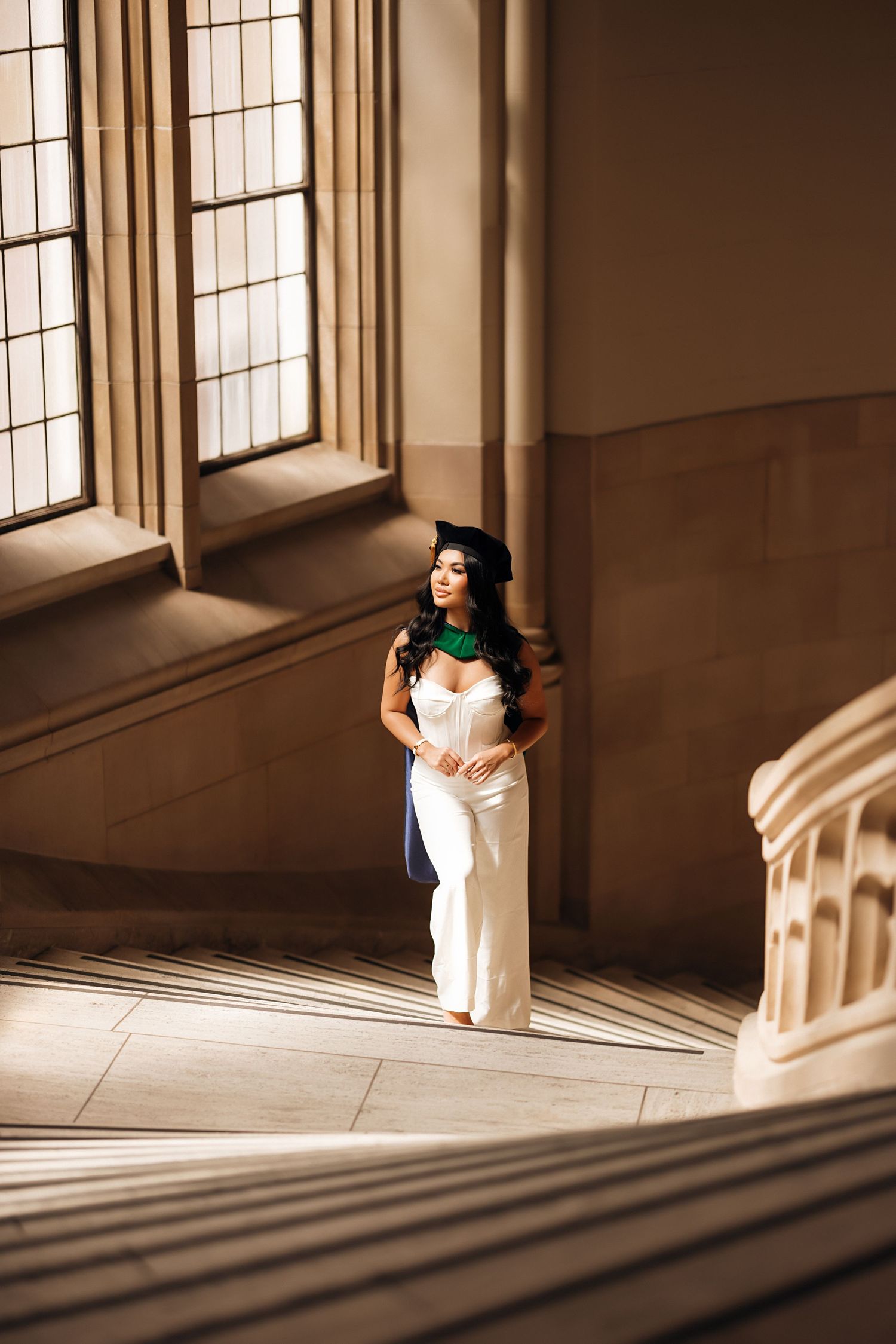 Figure in white dress standing in elegant interior with dramatic window lighting.