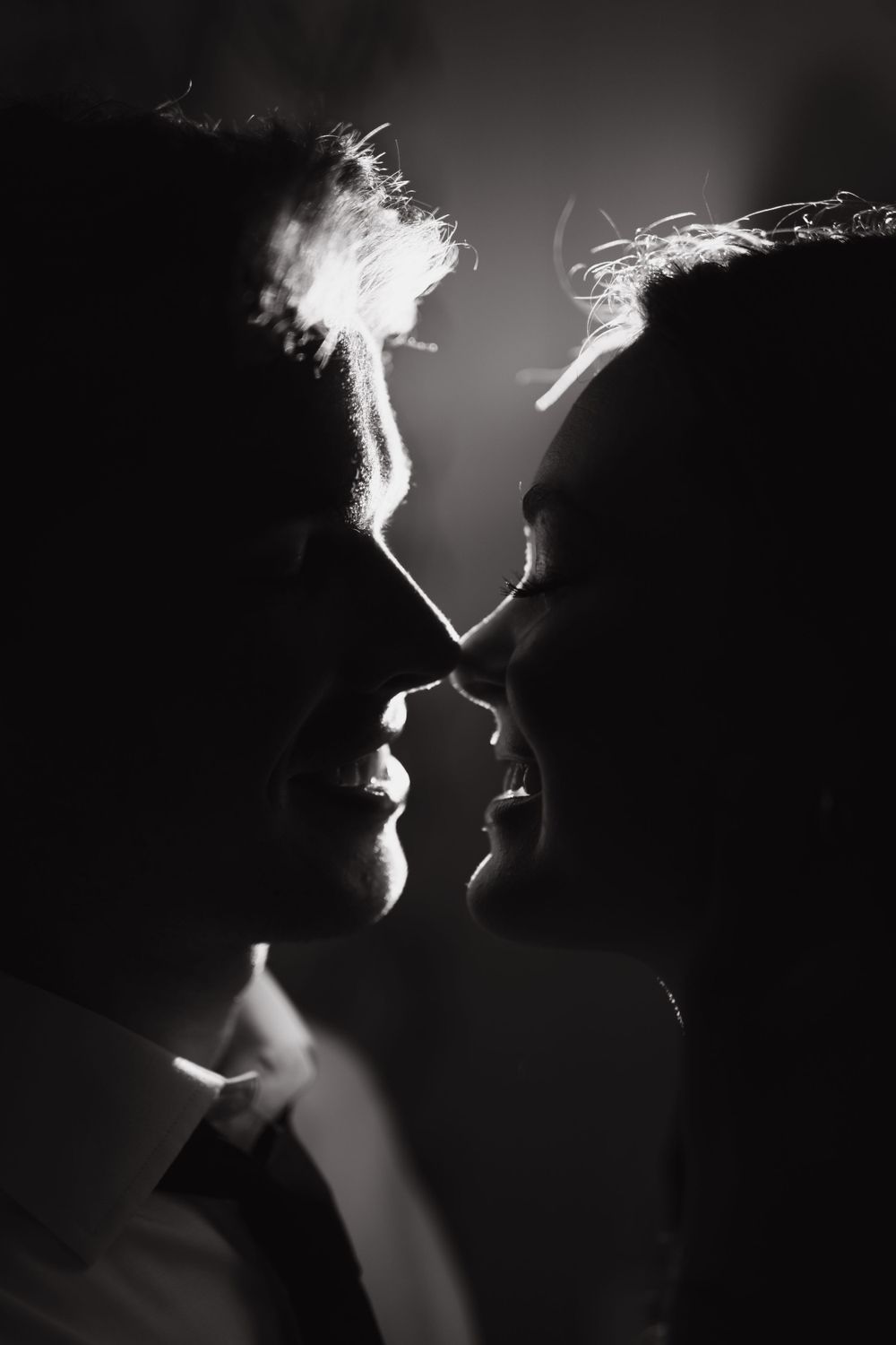Artistic black and white silhouette of a romantic couple about to kiss.