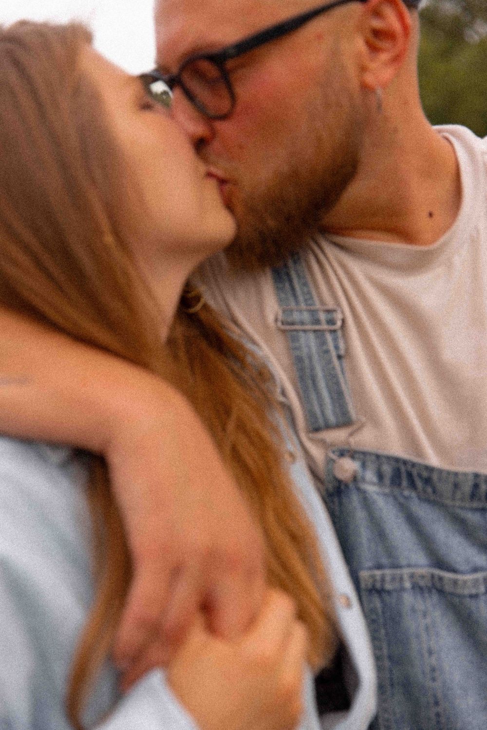 Close-up of intimate couple sharing a kiss in casual denim attire.